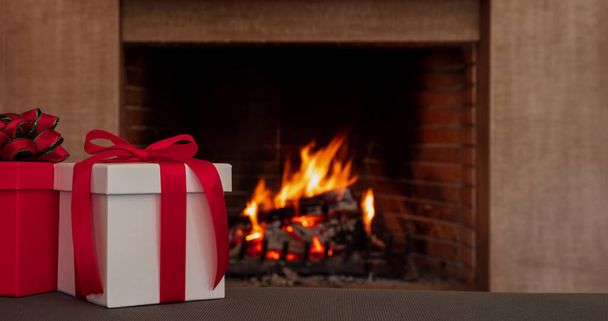 Cadeaux de Saint-Valentin ou de Noël, boîtes-cadeaux avec ruban rouge, fond de cheminée brûlant. Nuit romantique pour deux. Espace de copie, modèle de carte. - Photo, image