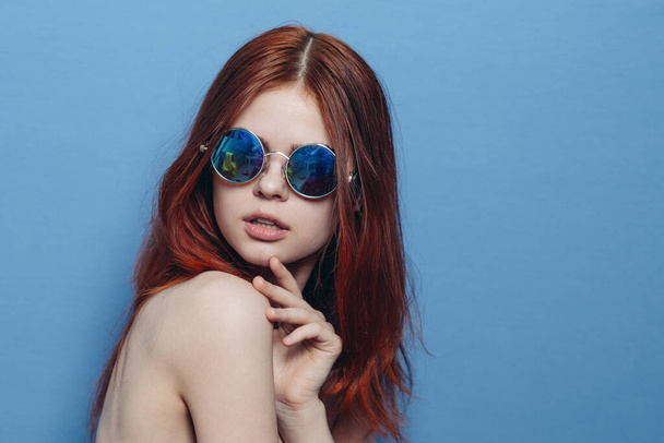 perky red-haired woman in blue glasses bare shoulders posing - Foto, Imagen