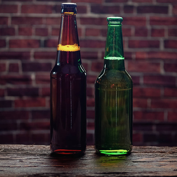 Two bottles of beer on the background of a brick wall - 写真・画像