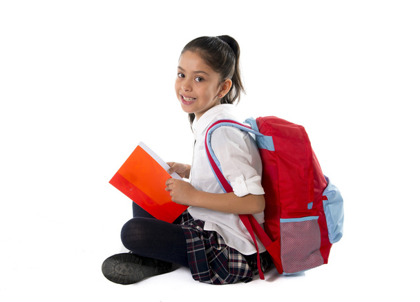 счастливый латинский ребенок, читающий учебник или блокнот, улыбаясь сидя на полу
  - Фото, изображение
