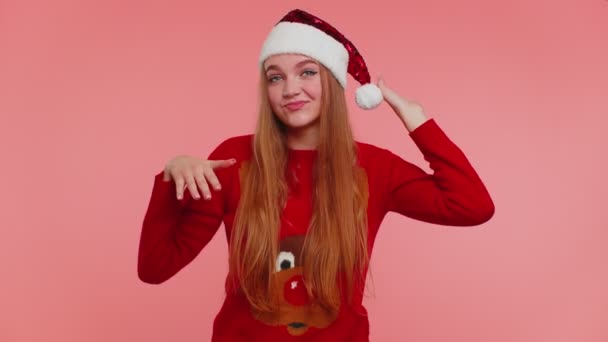 Loca chica en Navidad Santa suéter sombrero demostrando lengua fuera engañando alrededor de hacer caras tontas - Metraje, vídeo