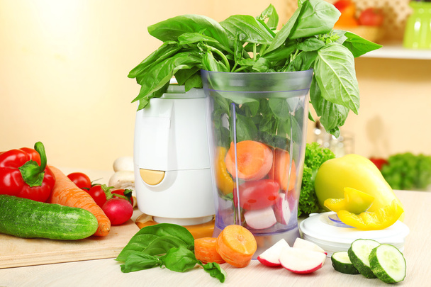 Blender with fresh vegetables on kitchen table - Fotó, kép