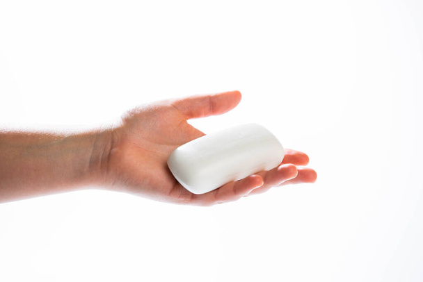 Primer plano de la mano con jabón aislado en el fondo blanco - Foto, Imagen