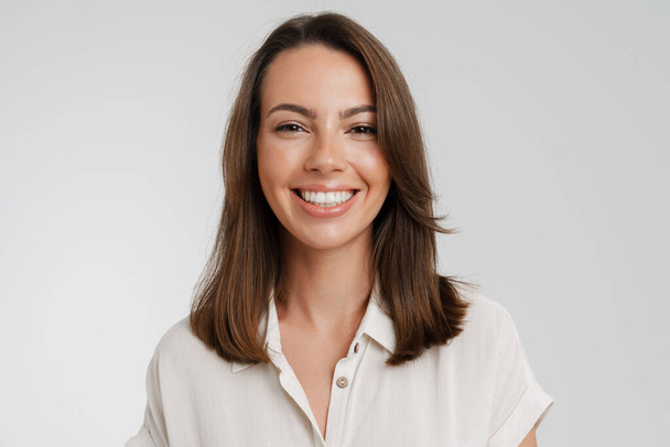 Young european woman in shirt smiling and looking at camera isolated over white background - Foto, afbeelding