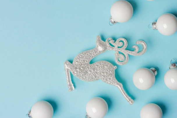 Composición de Navidad y Año Nuevo sobre fondo azul con un reno y adornos. - Foto, imagen