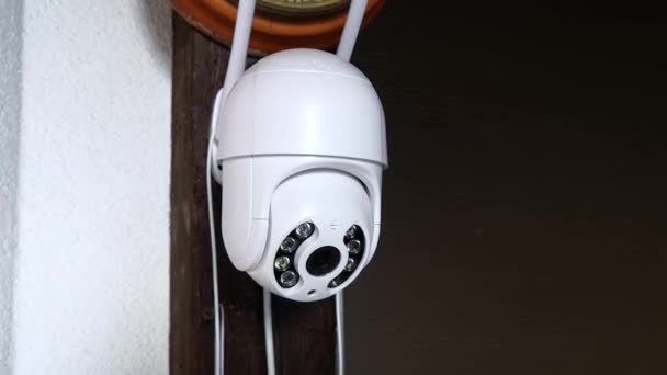 アンテナを備えたホワイトCCTVカメラが回転し、移動するオブジェクトを記録します。個人所有の警備システム。屋外ビデオ監視。映像だ。コピースペース。ウェブカメラ。ストリートコントロール。距離監視だ。スマート. - 映像、動画
