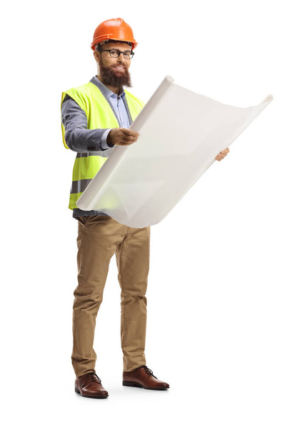 Full length shot of a site engineer holding a blueprint and wearing a helmet isolated on white background - Fotoğraf, Görsel