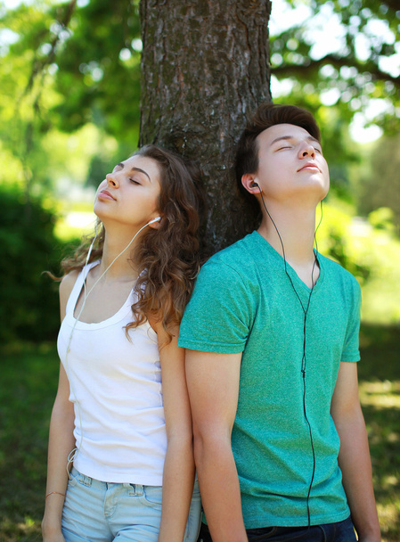 Teens, guy and girl in headphones enjoying listening to music in - Valokuva, kuva