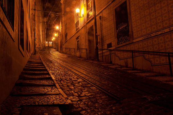 Stare europejskie Typowa scena miejska w wąskiej uliczce nocą, Lizbona, Portugalia. - Zdjęcie, obraz