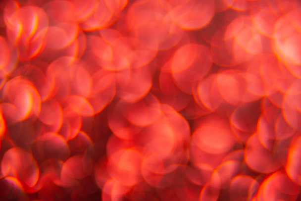 Textura creada a partir de objetos de color rojo ovalado. El efecto se obtuvo fotografiando la superficie del brillo en una escala macro sin enfocarse. - Foto, imagen