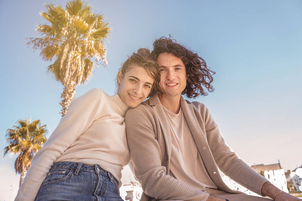 junges heterosexuelles Paar unter blauem Himmel, glücklich lächelnd - Foto, Bild