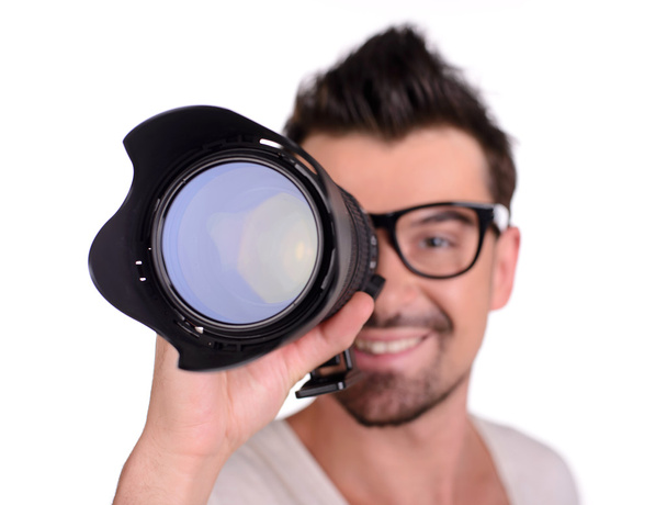 Funny man photographer looking through the objective lens, isolated on white - Foto, Imagem