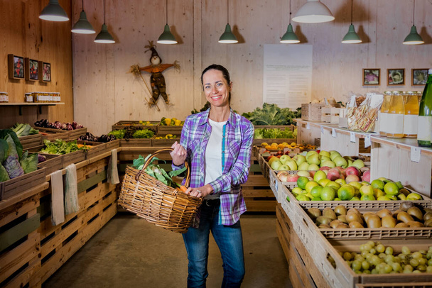 Portrét krásné brunetky dívky vybírající ovoce a zeleninu na farmářském trhu. Udržitelný životní styl - Fotografie, Obrázek