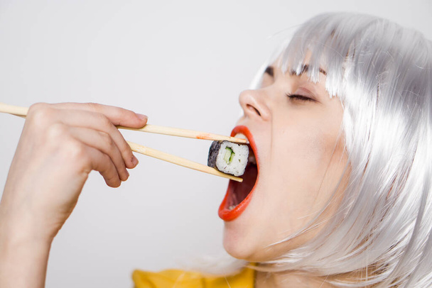 pretty woman in white wig and sushi with Japanese chopsticks - Photo, image