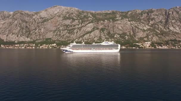 Cruiseschip vaart op zee tegen de achtergrond van een bergketen - Video