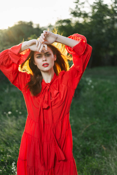 attractive woman in red dress outdoors in freedom field - Φωτογραφία, εικόνα