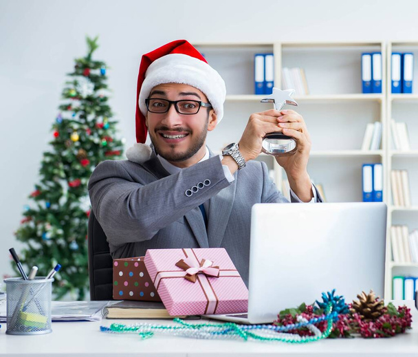Young businessman celebrating christmas in the office - Photo, Image