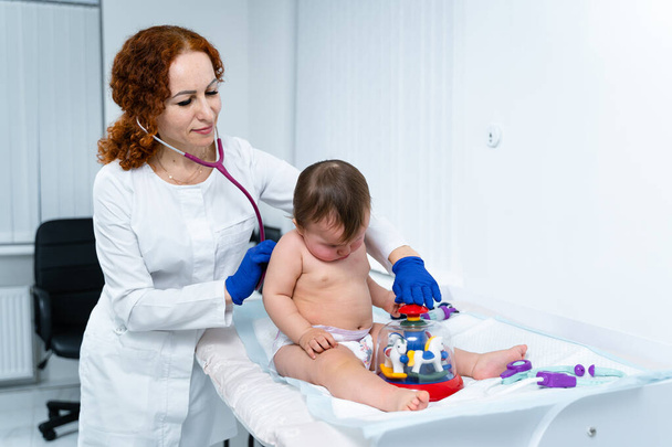 Little girl at doctor for checkup. Doctor pediatrician and baby patient. Child patient at doctor appointment. Pediatrician checking kid's health. Medical examination by a neonotologist doctor of baby. - Photo, Image