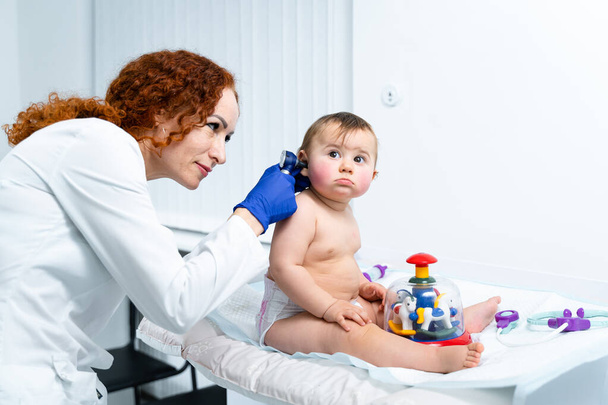 Egy kislány az orvosnál kivizsgálásra. Orvos gyermekorvos és baba beteg. Gyermek beteg az orvosnál. A gyerekorvos ellenőrzi a gyerek egészségét. A csecsemő neonotológus orvosa által végzett orvosi vizsgálat. - Fotó, kép