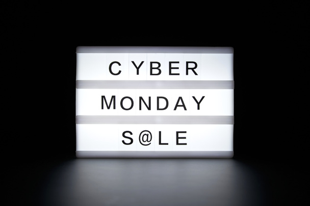 Cyber Monday venda é escrita em uma caixa de luz brilhante em um fundo escuro. - Foto, Imagem
