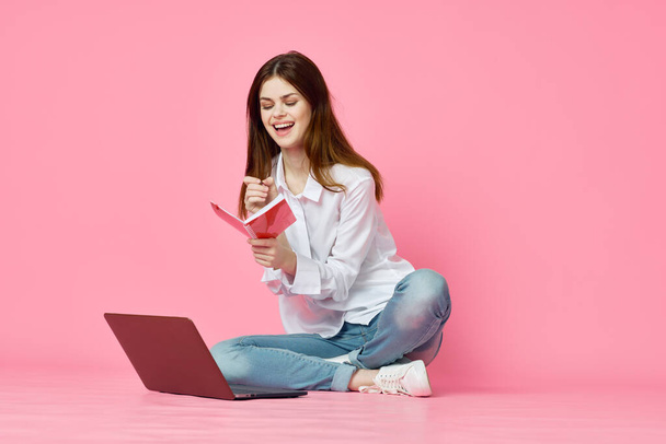 woman sitting on floor with laptop shopping entertainment pink background - Φωτογραφία, εικόνα