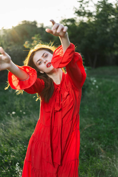 attractive woman in red dress outdoors in freedom field - Фото, зображення