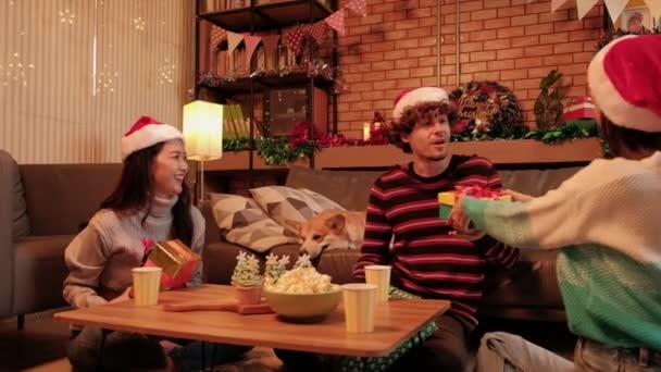 Surprise three friends and family by joyful giving gifts together and exchange while happiness holiday in home's living room, is decorated for Christmas festival celebration and the new year party. - Footage, Video