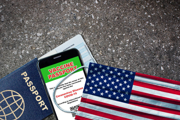 Verenigde Staten nieuwe normale reizen met paspoort, digitaal vaccin op smartphone, instapkaart en gezichtsmasker met Amerikaanse vlag. Vaccin paspoort concept met kopieerruimte. - Foto, afbeelding