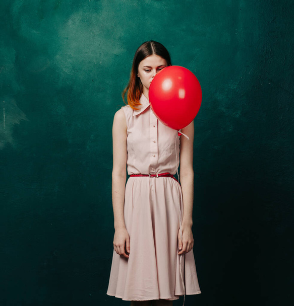 woman with red balloon on green background holiday fun - Фото, изображение
