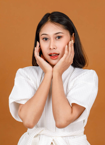 千年の若いアジアの短い黒髪の女性モデルのポートレートスタジオショット白いシャワーロープで立って笑顔見てカメラポーズで広告アクションで茶色の背景. - 写真・画像