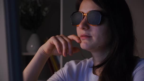 A woman in perforated glasses looks at the computer screen. - Footage, Video