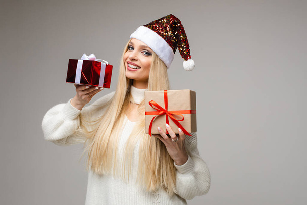 Lächelnde schöne Frau zeigt Weihnachtsgeschenke im Atelier - Foto, Bild