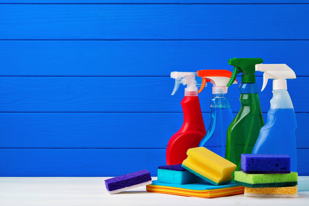 Various cleaning items against blue wooden background - Fotografie, Obrázek