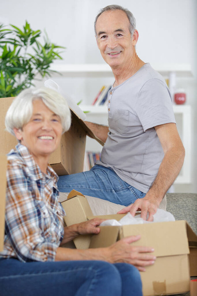 mature couple with boxes after moving into new house - Foto, Bild
