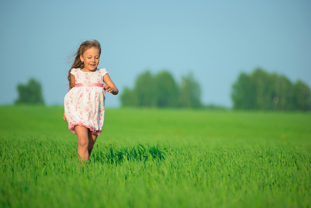 グリーン麦畑で走っている少女 - 写真・画像