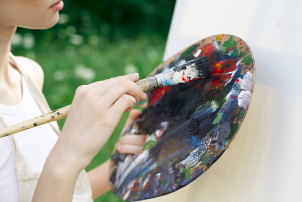 Beyaz elbiseli kadın ressam boya paleti yakın plan çiziyor. - Fotoğraf, Görsel