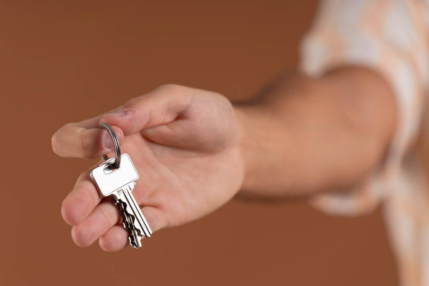 Close-up of a mans hand handing over a set of keys - Photo, Image
