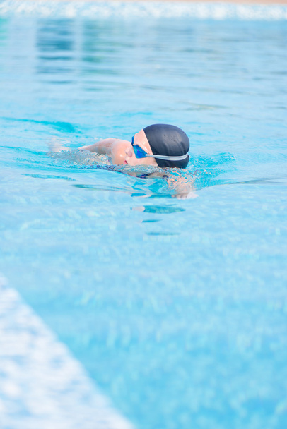 Woman in goggles swimming front crawl style - Fotoğraf, Görsel