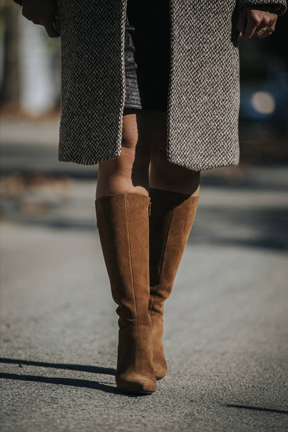 A vertical shot of woman wearing fashionable brown suede knee-high boots outdoors - Valokuva, kuva