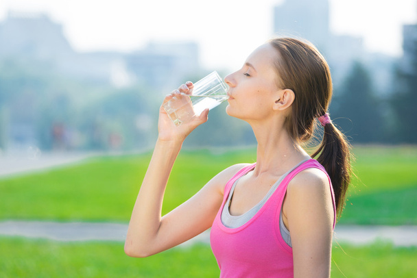 Vrouw die water drinkt na inspanning - Foto, afbeelding