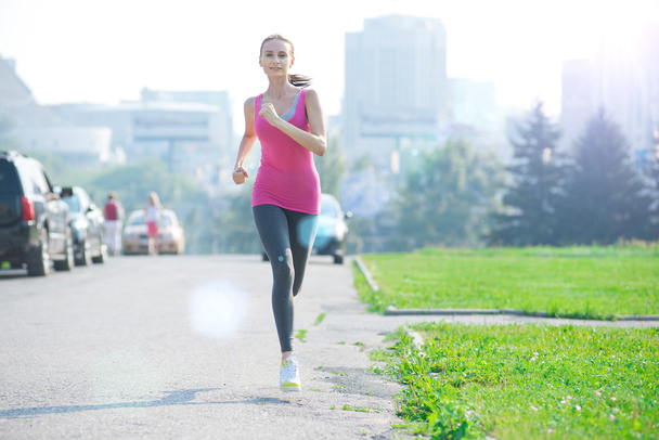 Woman running in city park - Фото, изображение