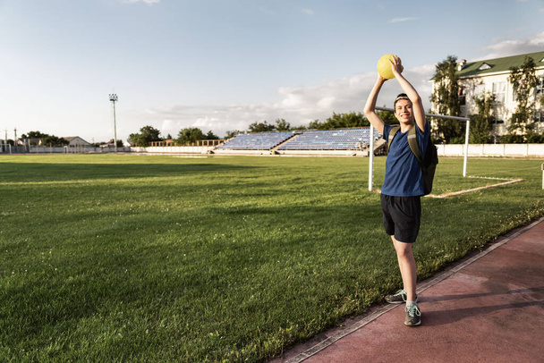 concept of sports and health - teen boy posing at a stadium, a soccer field with green grass. - Φωτογραφία, εικόνα