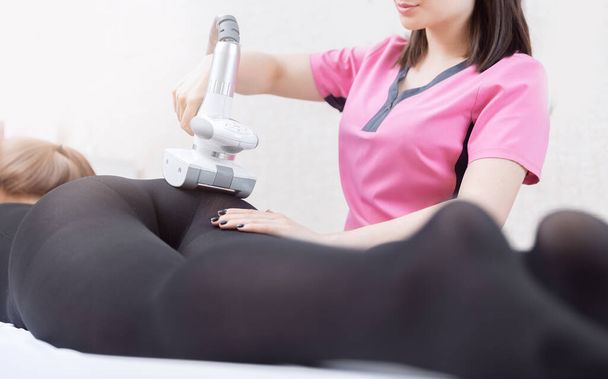 足を持ち上げるために、体の女性からセルライトを除去するためのバナーLPGマッサージ。スパサロンでのコンセプト美容療法、白の背景 - 写真・画像