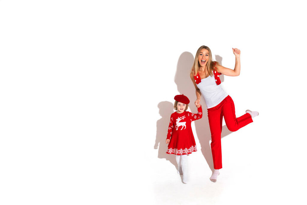 Schattig kind en mooie dame beide gekleed in rood - Foto, afbeelding