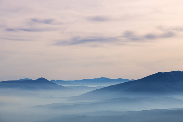 A mesmerizing view of Svrljig mountains over the hills on a foggy day in Serbia - Foto, imagen