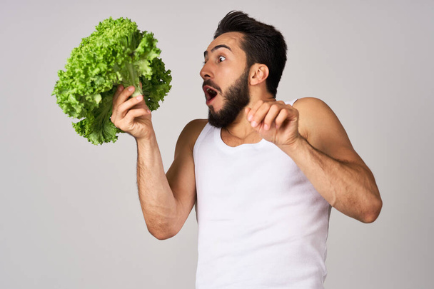 cheerful man in a white t-shirt lettuce leaves healthy food - Fotó, kép
