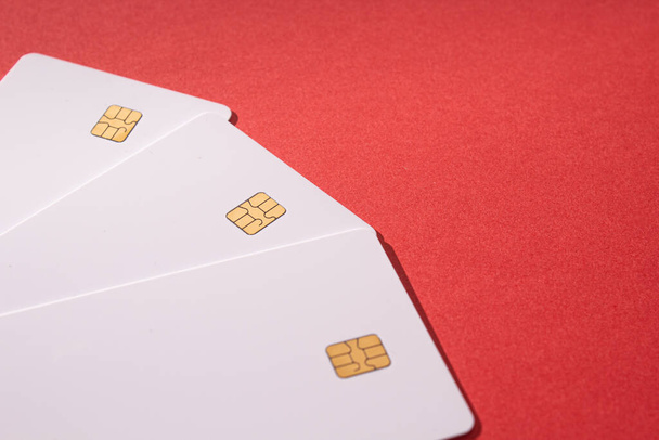 A closeup of the white cards with a chip on a red background. - 写真・画像