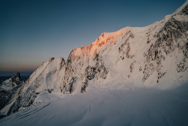 Big alpine wall with snow, ice, seracs and creavasses. Peuterey ridge, sunrise over Brenva face of Mont Blanc, Chamonix, France. - Fotografie, Obrázek