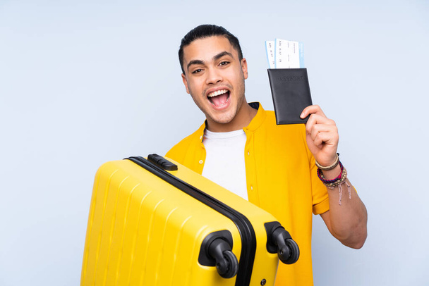 Azji przystojny mężczyzna odizolowany na niebieskim tle na wakacjach z walizką i paszportem - Zdjęcie, obraz