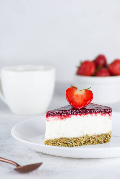 Een stukje rauwe mousse bloemkool cake met aardbeien op een lichte achtergrond. Suiker, gluten, lactosevrij, veganistisch. - Foto, afbeelding